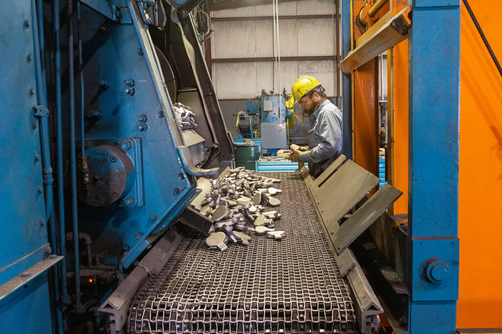 Stump grinding feeds being inspected as they come out of the wheelabrator